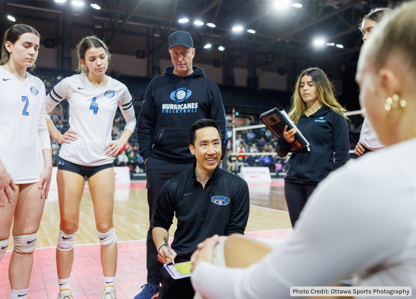 Volleyball Coach surrounded by players